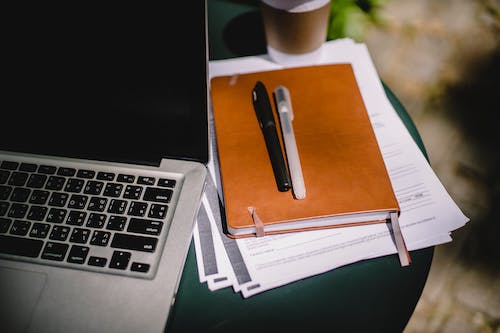 Free Planner and pens on table with laptop Stock Photo