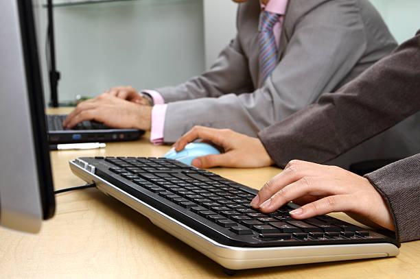 Office workers typing on a keyboard stock photo