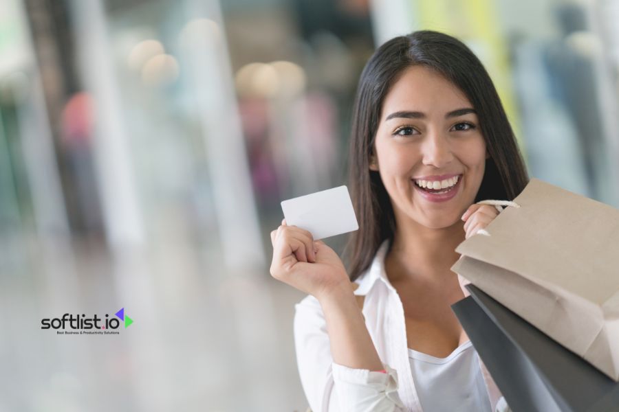 Smiling woman holding a card with shopping bags.