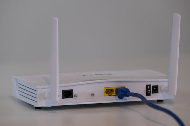 Back view of a router with connected ethernet cable.