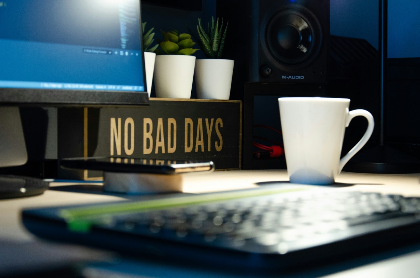 Desk setup with a coffee mug and a 'No Bad Days' sign.