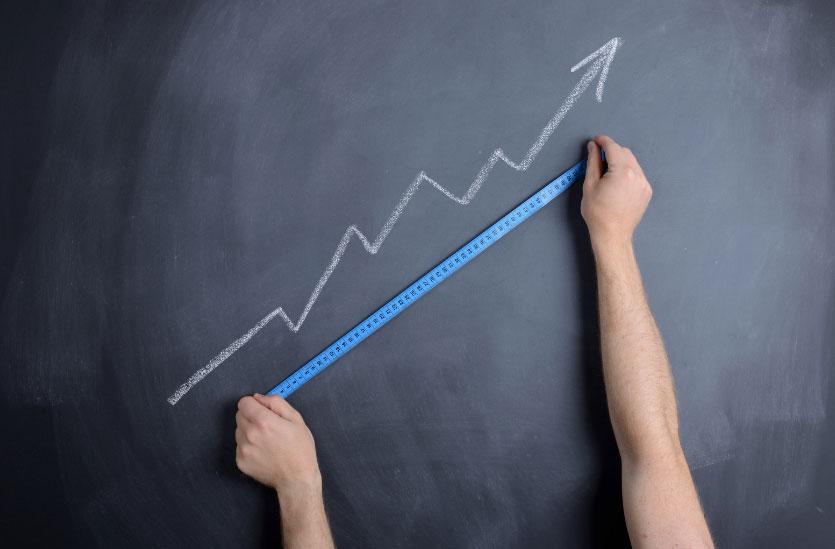 A person measuring a graph on a chalkboard