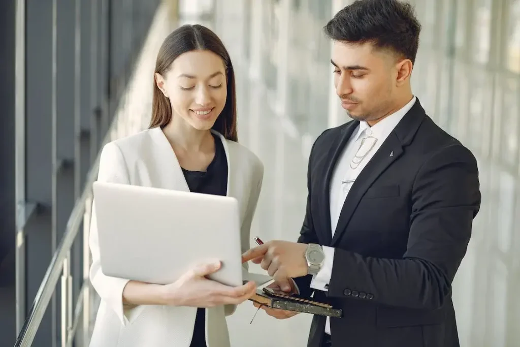 a man and woman looking at a laptop